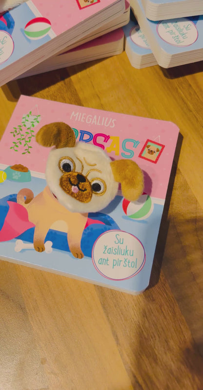 Miegalius mopsas. Su žaisliuku ant piršto